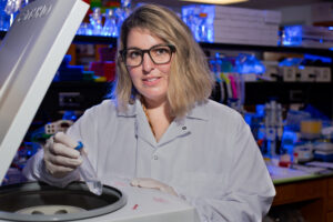 Scientist working with centrifuge in laboratory.