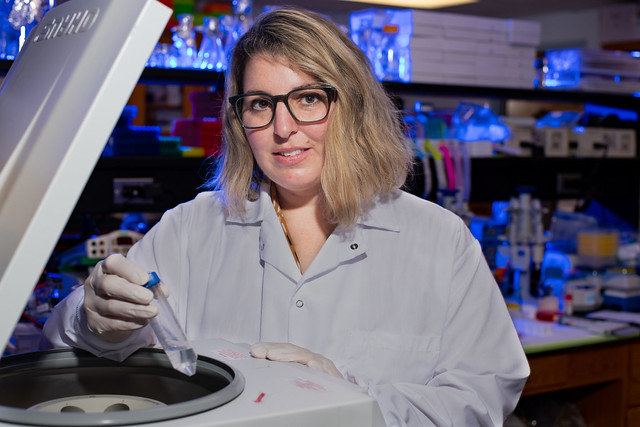 Scientist working with centrifuge in laboratory.